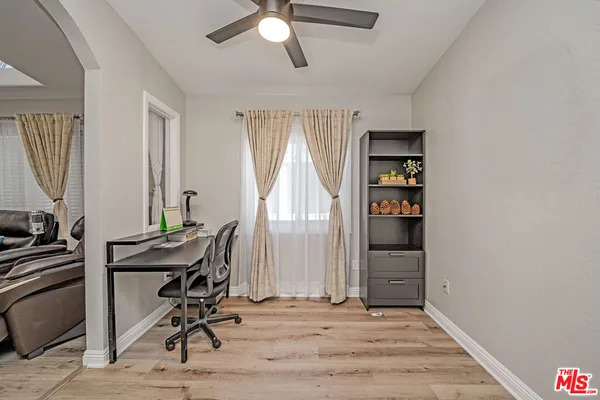 a view of a workspace with furniture and a window