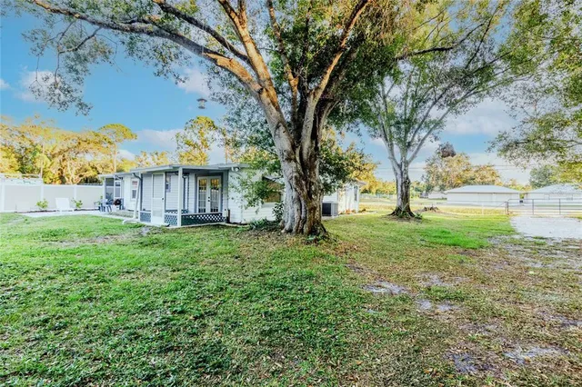 a view of yard with green space and fountain in the back