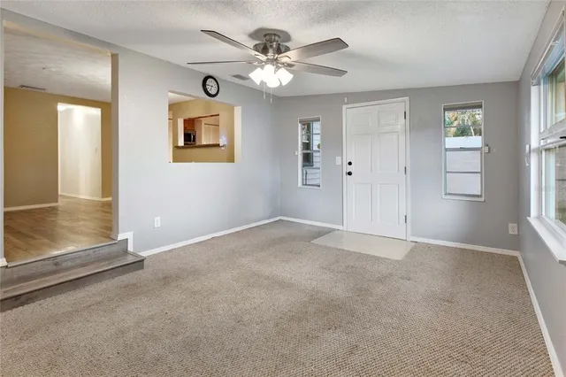 an empty room with fan and windows