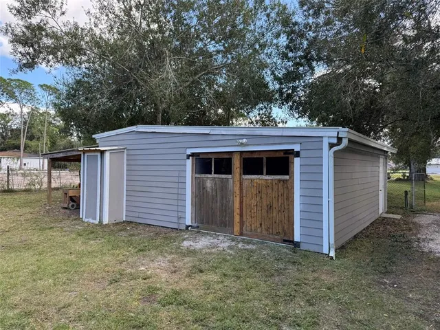 a view of a wooden house with a large window and large tree