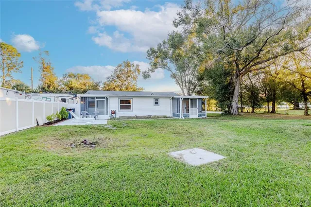a view of a house with a yard and tree s