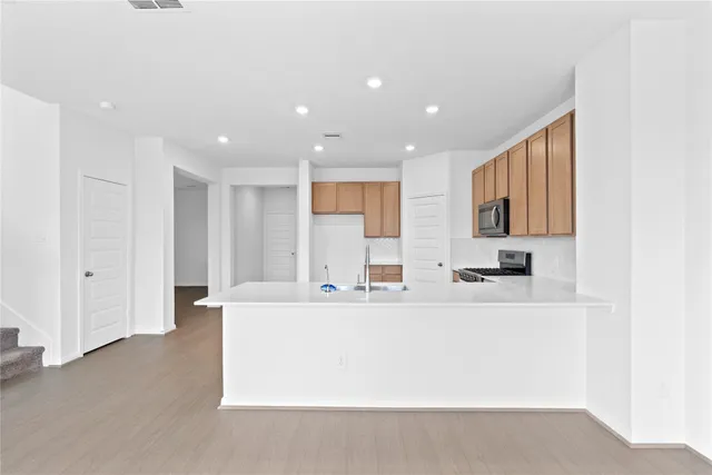 a view of a kitchen with an empty room and a window