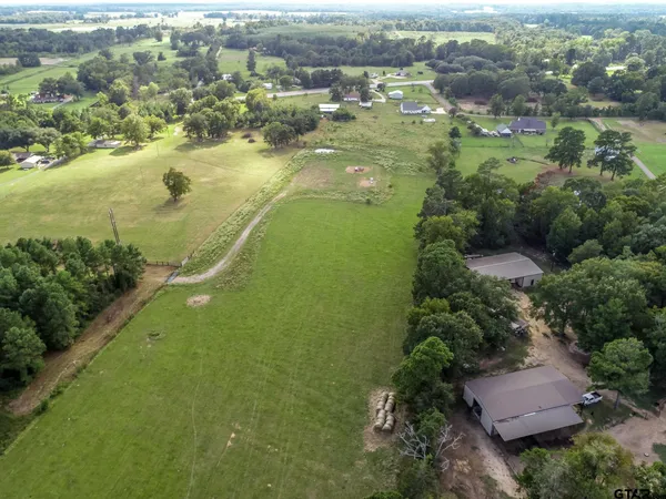 an aerial view of a house with pool a yard and lake view