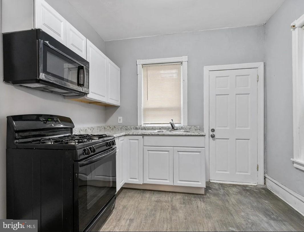 5224 Rodman Street Philadelphia, PA 19143 - Photo 5 of 12 a kitchen with stainless steel appliances granite countertop a stove microwave and sink