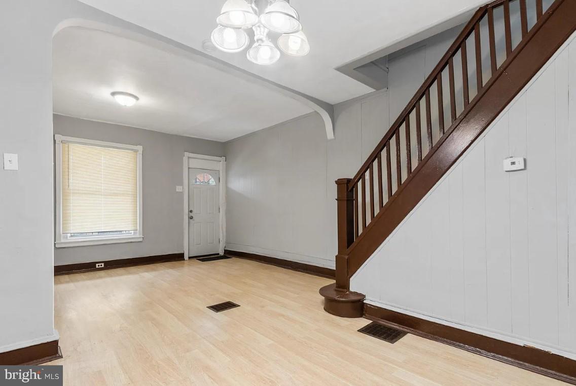 5224 Rodman Street Philadelphia, PA 19143 - Photo 6 of 12 a view of an empty room with wooden floor and stairs