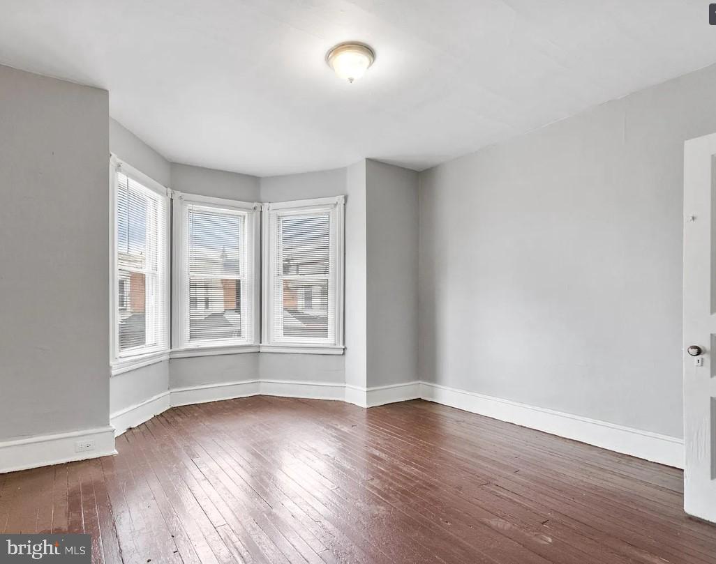 5224 Rodman Street Philadelphia, PA 19143 - Photo 8 of 12 an empty room with wooden floor and windows