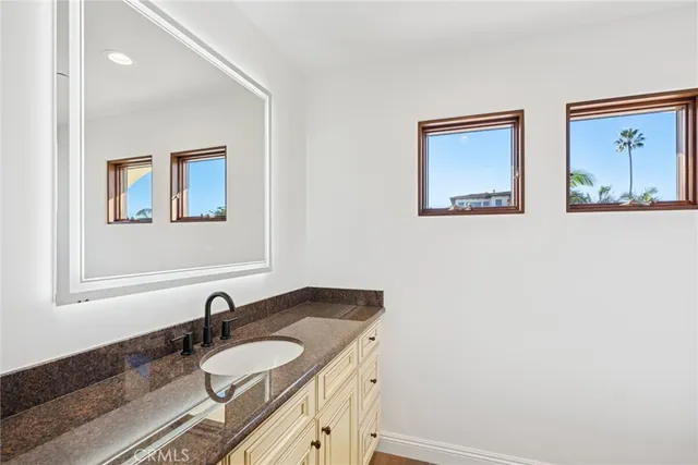 a bathroom with a granite countertop sink and a mirror