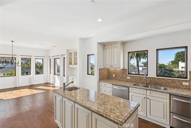 a large kitchen with granite countertop a sink and dishwasher next to a large window