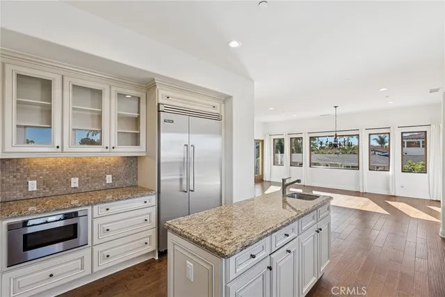 a kitchen with granite countertop a sink stove and refrigerator
