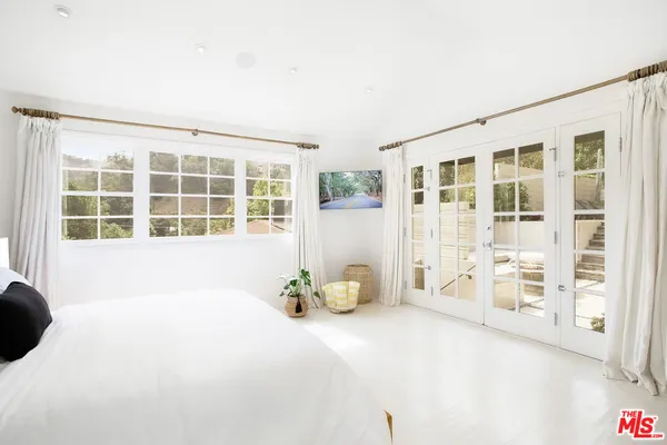 a bedroom with furniture and large windows