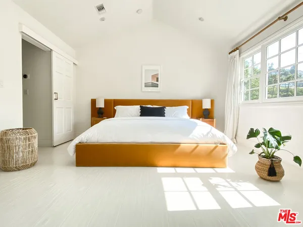 a bedroom with a bed and a potted plant