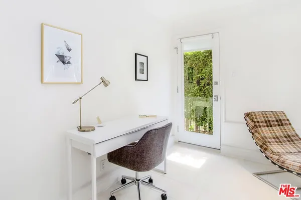 a view of a workspace with furniture and a window