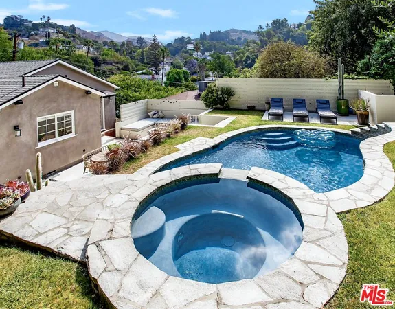 an aerial view of a house with swimming pool and mountain view