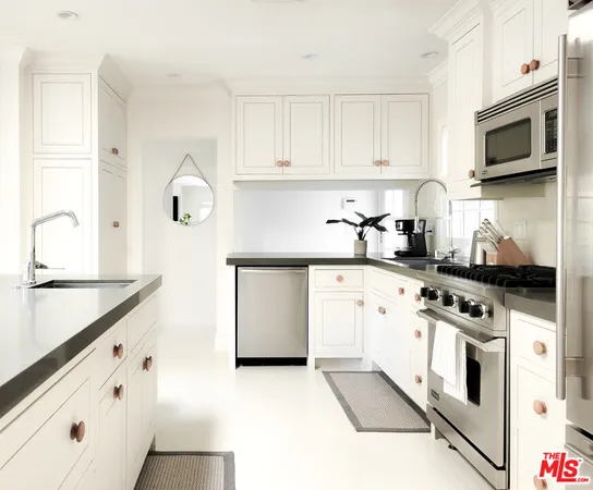 a kitchen with granite countertop white cabinets and white appliances
