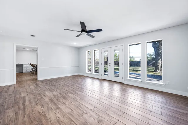 a kitchen with stainless steel appliances granite countertop a sink a stove a refrigerator and island with wooden floor