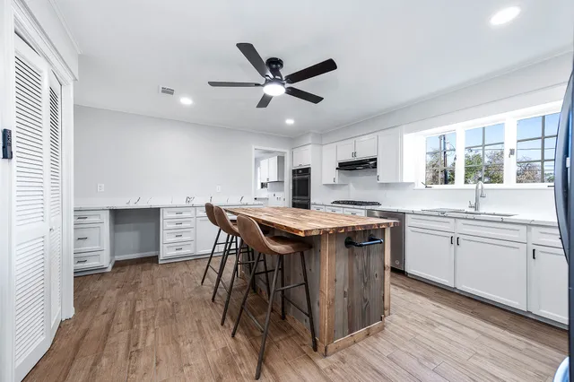 a kitchen with a stove and a wooden floor