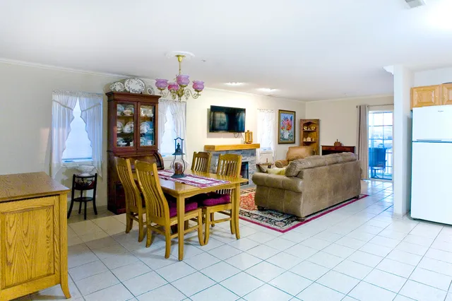 a living room with furniture a flat screen tv and a table