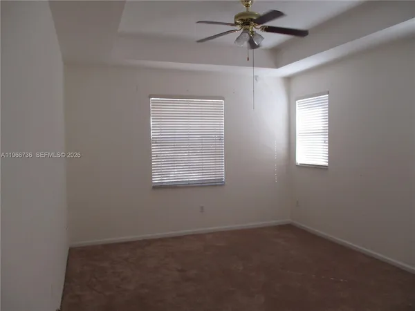 an empty room with a window and a fan