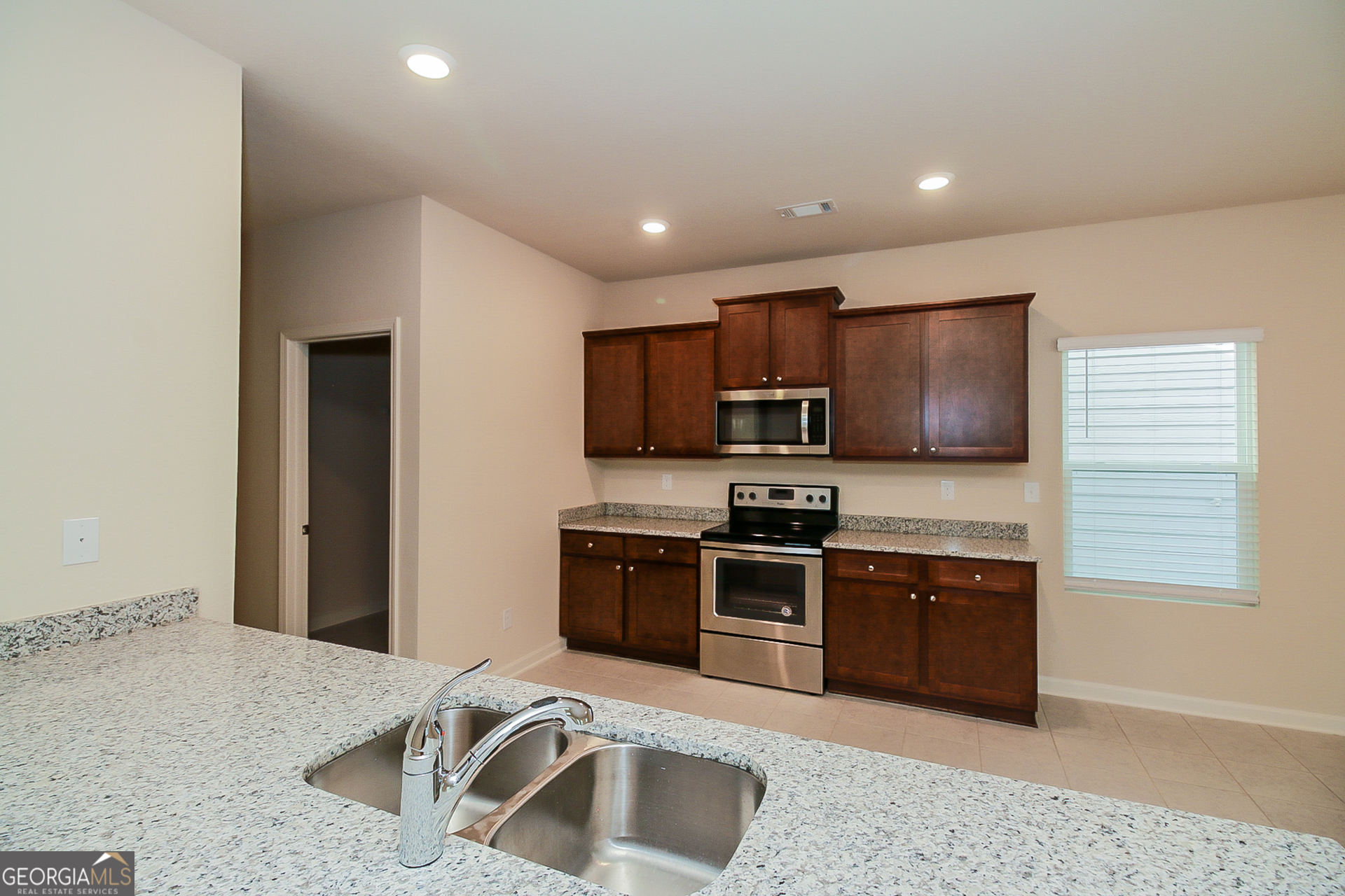 10902 Wheeler Trace Hampton, GA 30228 - Photo 5 of 17 a kitchen with stainless steel appliances granite countertop a sink stove and refrigerator