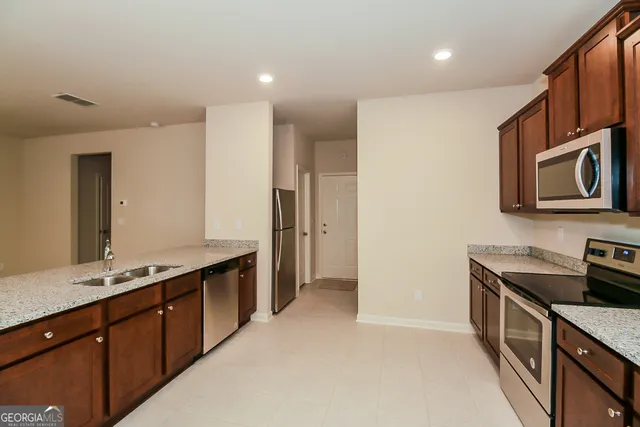 a kitchen with stainless steel appliances granite countertop a sink and a stove top oven