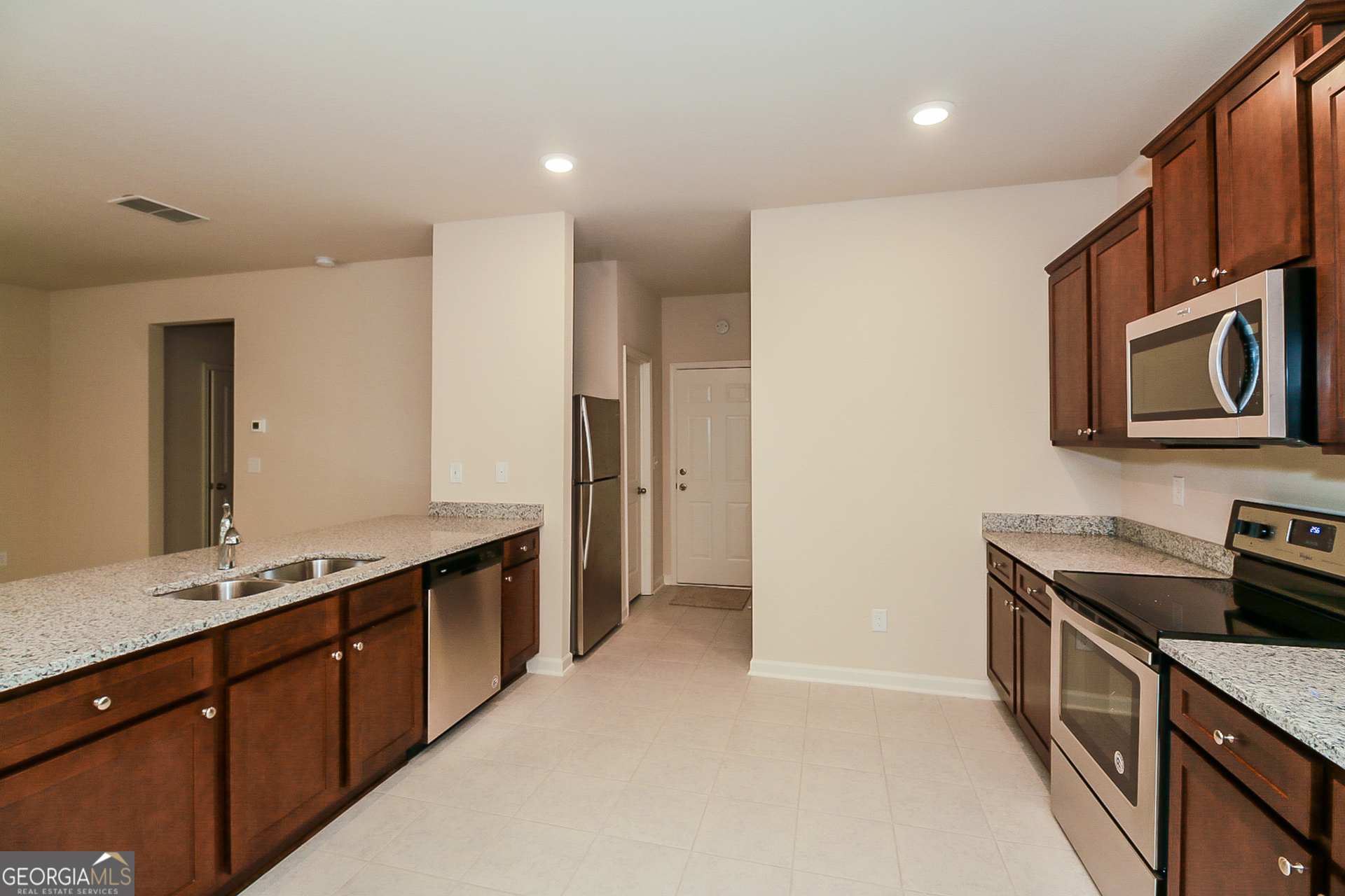 10902 Wheeler Trace Hampton, GA 30228 - Photo 6 of 17 a kitchen with stainless steel appliances granite countertop a sink and a stove top oven