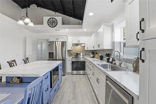 a kitchen with a stove a sink and a refrigerator