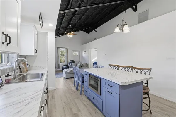 a very nice looking room with kitchen countertop a stove a chimney a sink and cabinets