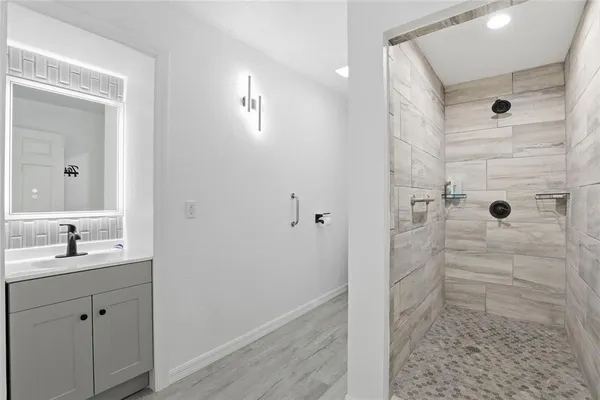a bathroom with a shower sink and mirror