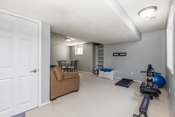 a living room with furniture and a gym machine