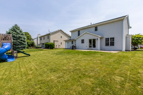 a view of a house with a big yard and large trees