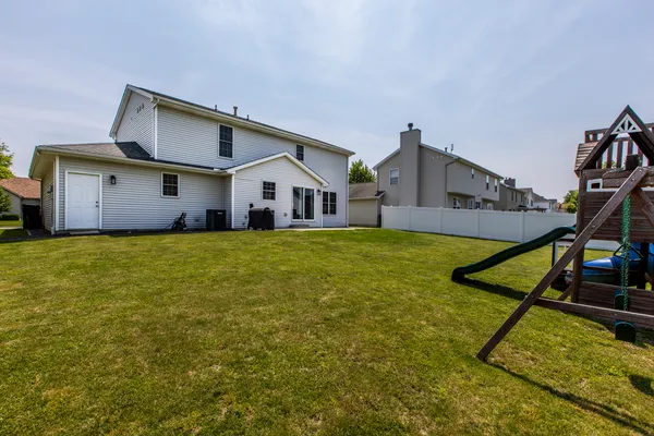 a view of a house with a yard and sitting area