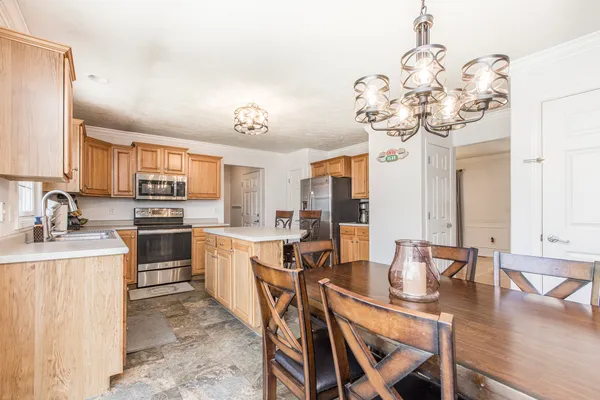a kitchen with a dining table chairs sink and stove