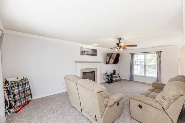 a living room with furniture a fireplace and a flat screen tv