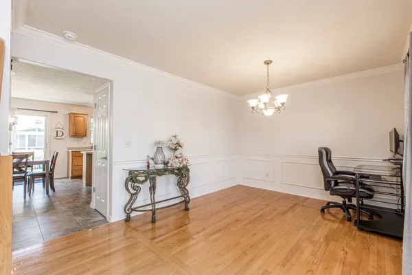 a workspace with furniture wooden floor and a chandelier