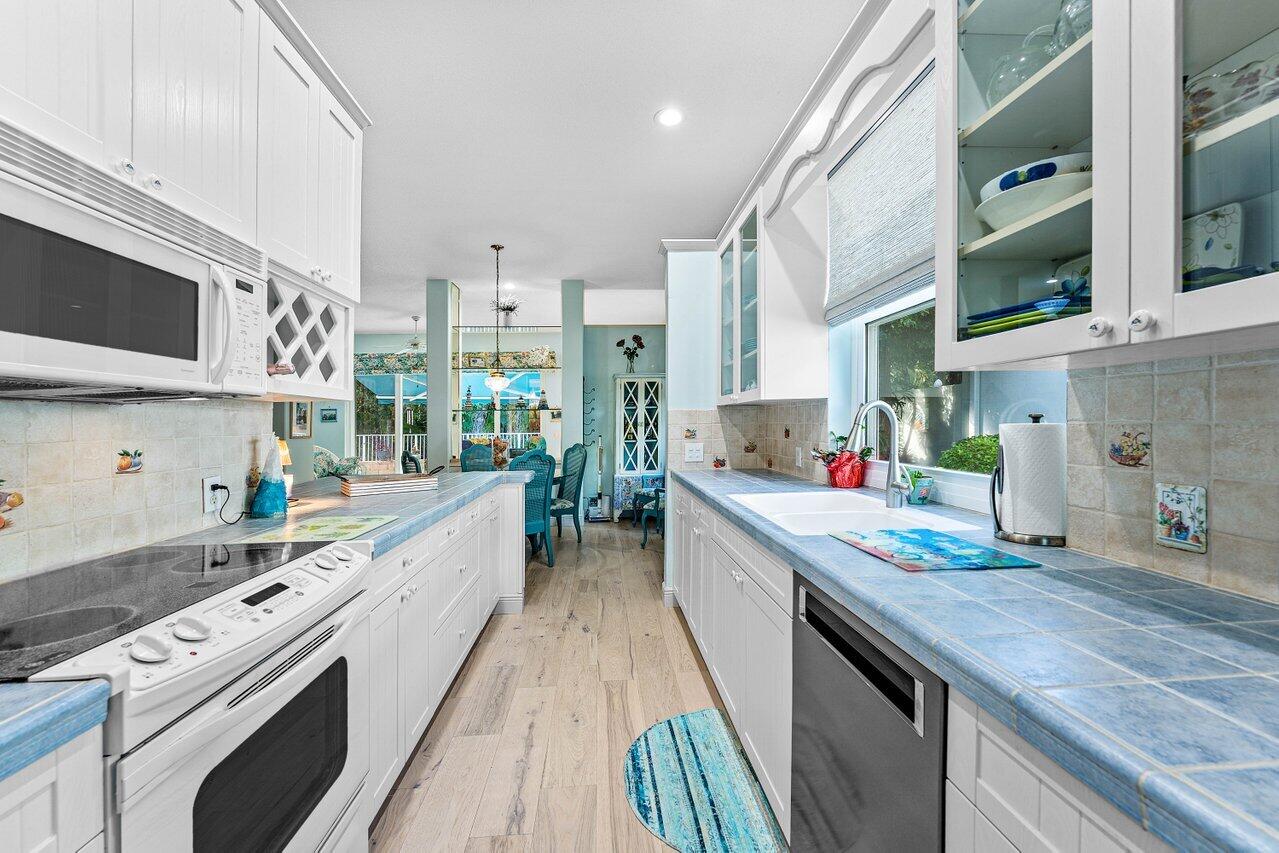 198 Hampton Circle Jupiter, FL 33458 - Photo 17 of 32 a large kitchen with stainless steel appliances granite countertop a lot of counter space and wooden floor