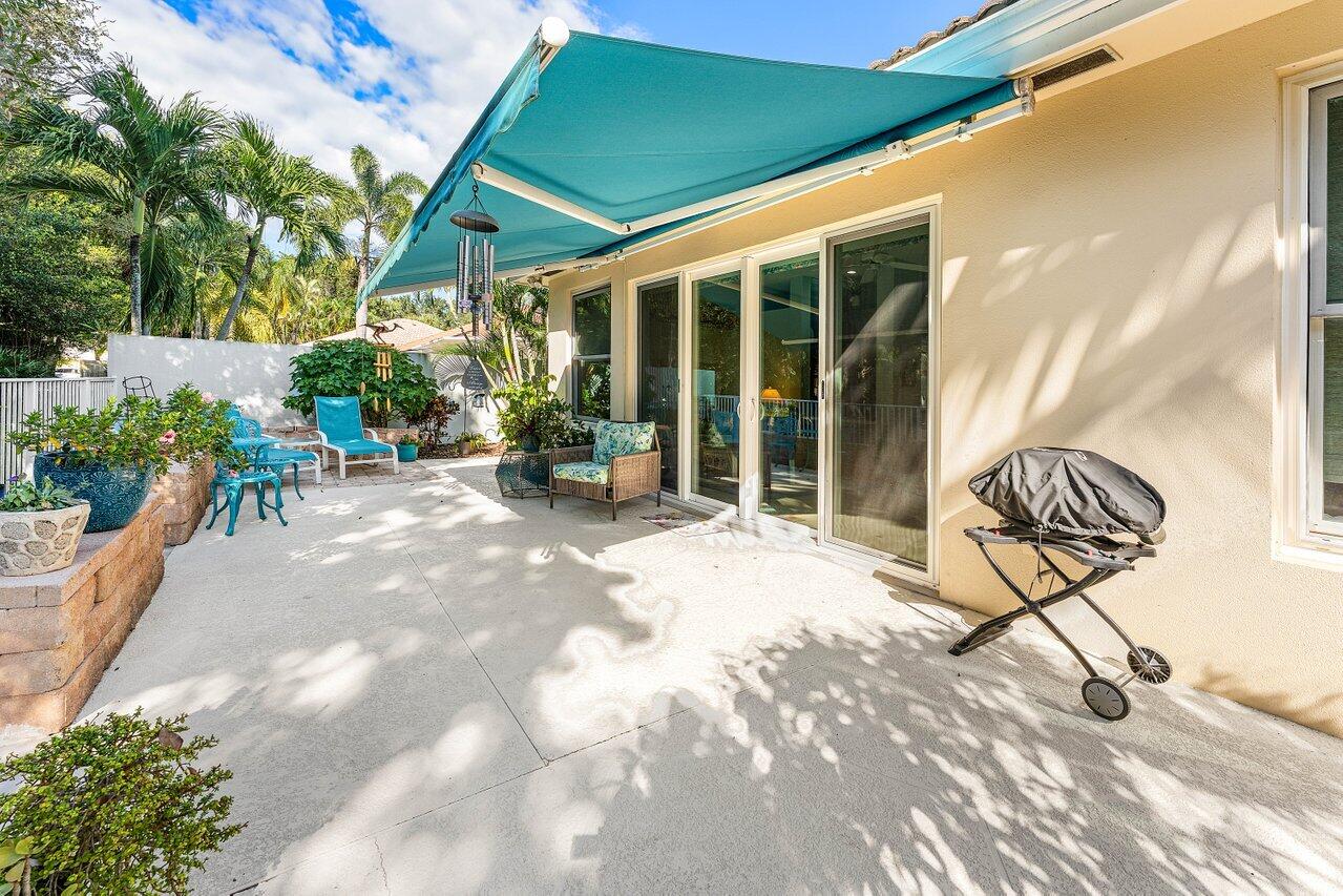 198 Hampton Circle Jupiter, FL 33458 - Photo 30 of 32 a view of a chair and tables in the patio
