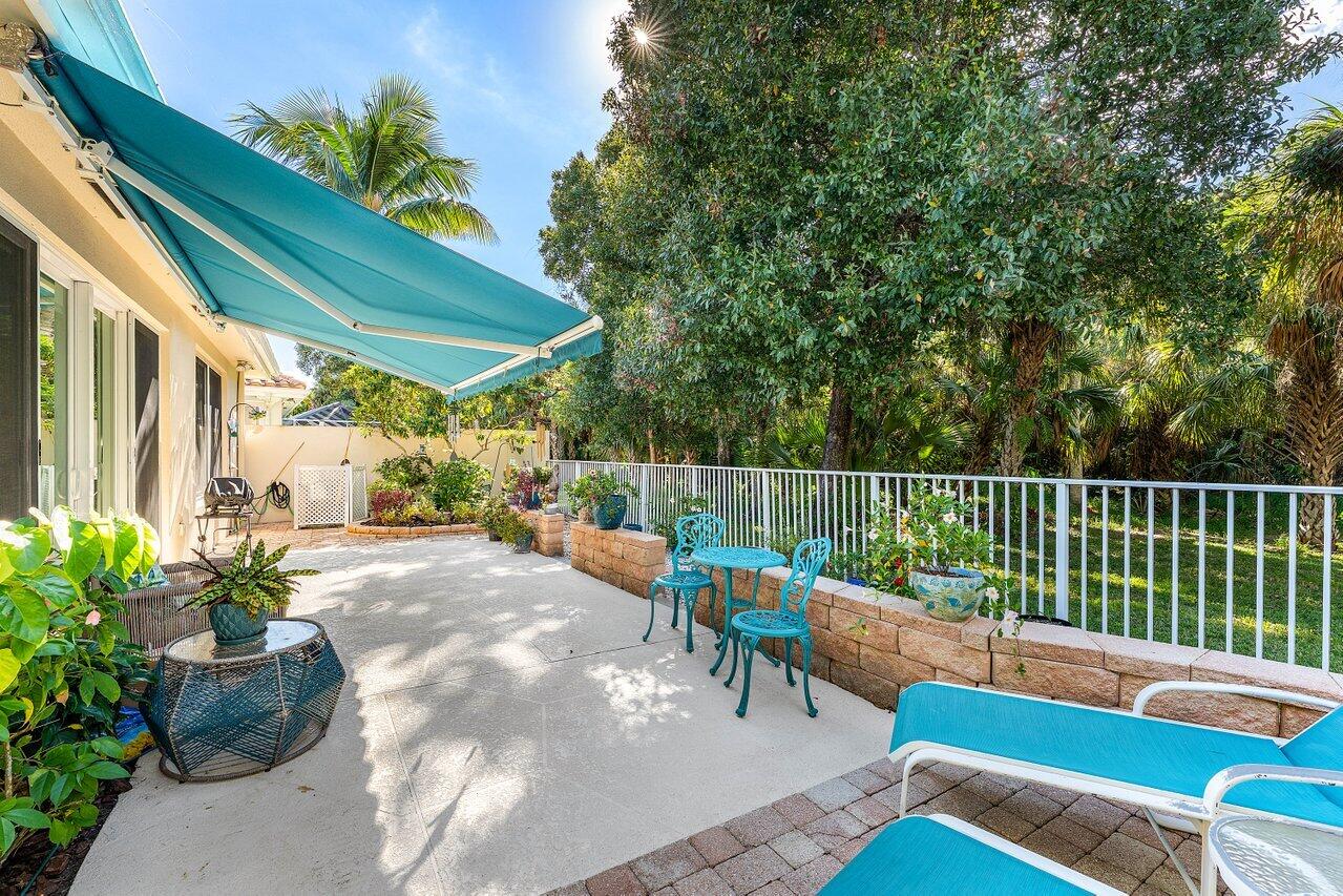 198 Hampton Circle Jupiter, FL 33458 - Photo 31 of 32 a view of a chairs and tables in the back yard of the house