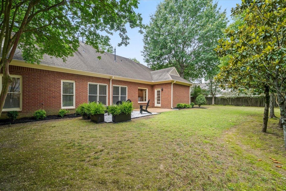 1876 Liles Lane Collierville, TN 38017 - Photo 28 of 36 Expansive backyard featuring a manicured lawn, mature trees, and a brick exterior