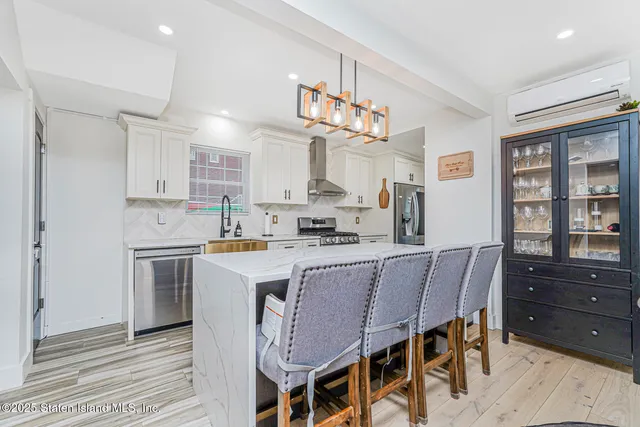 a kitchen with a dining table chairs cabinets and stainless steel appliances