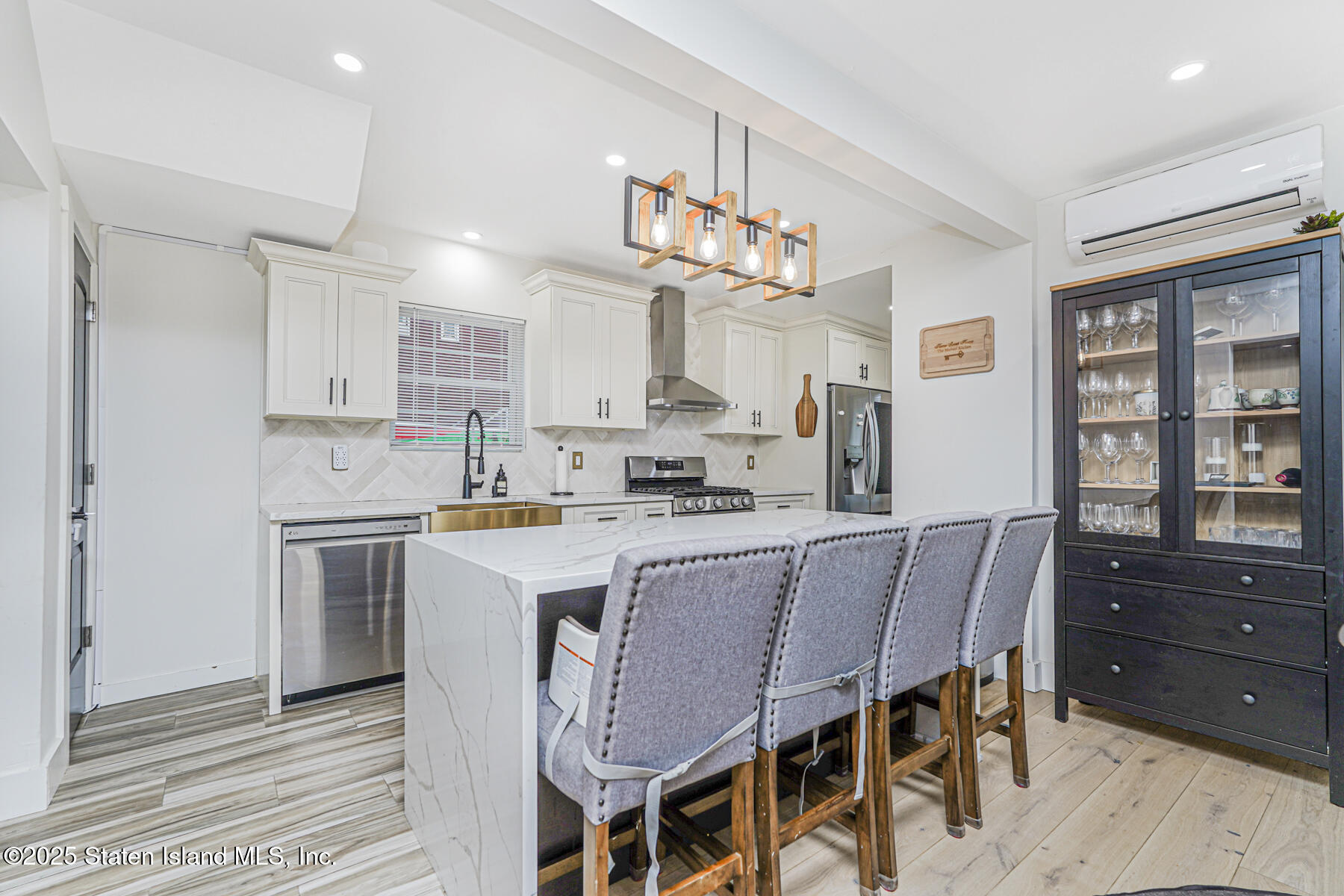 145 Clinton Place Staten Island, NY 10302 - Photo 13 of 41 a kitchen with a dining table chairs cabinets and stainless steel appliances
