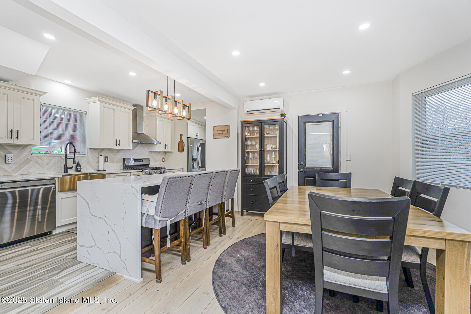 145 Clinton Place Staten Island, NY 10302 - Photo 18 of 41 a view of kitchen with stainless steel appliances granite countertop dining table chairs sink and white cabinets