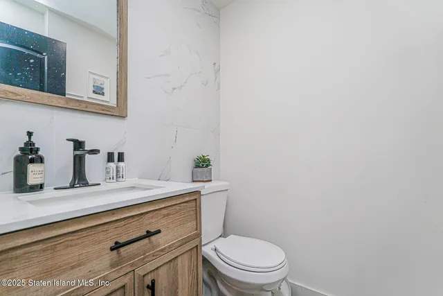 a bathroom with a granite countertop toilet sink and mirror
