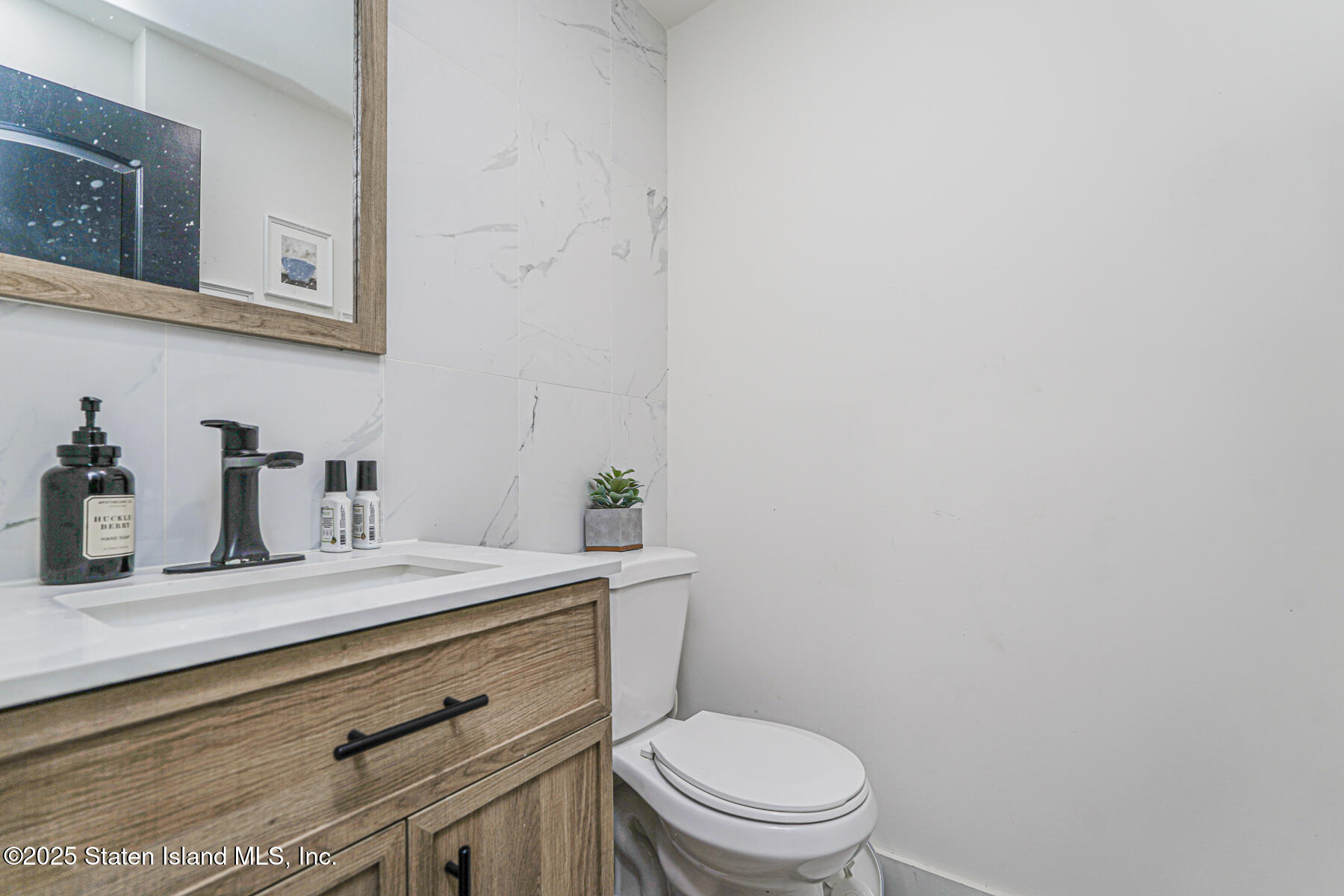 145 Clinton Place Staten Island, NY 10302 - Photo 23 of 41 a bathroom with a granite countertop toilet sink and mirror