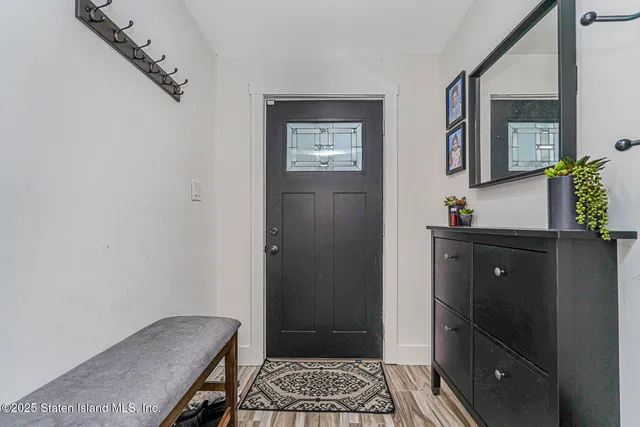 a view of a hallway with wooden floor and a mirror