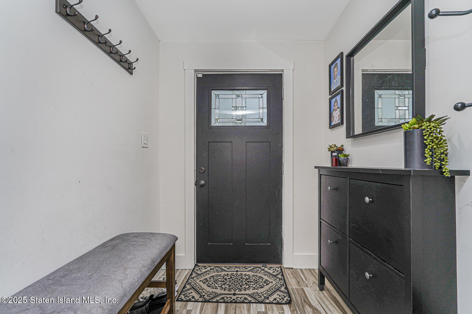 145 Clinton Place Staten Island, NY 10302 - Photo 3 of 41 a view of a hallway with wooden floor and a mirror