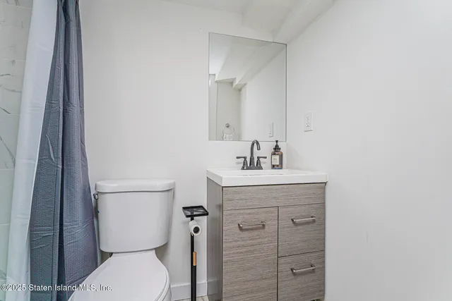 a bathroom with a toilet a sink and mirror