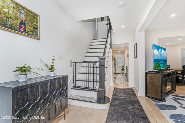 a view of a hallway with wooden floor and stairs
