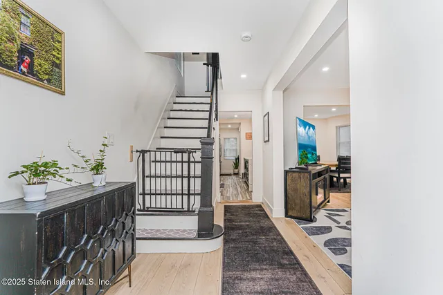 a hallway with a flower pot and wooden floor