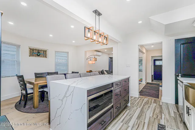 a kitchen with a sink a counter top space stainless steel appliances and a chandelier