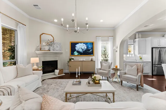 a living room with furniture a chandelier and a fireplace